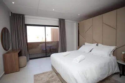 a bedroom with a large white bed and a balcony at Atlas Twin in Marrakech