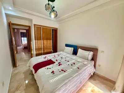 a bedroom with a large bed with roses on it at Appartement à louer in Marrakech