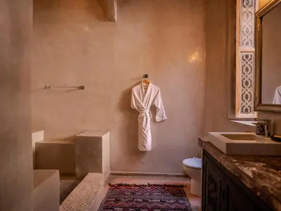 a bathroom with a robe hanging on the wall at Riad MAYAN Heated Pool and GYM in Marrakech