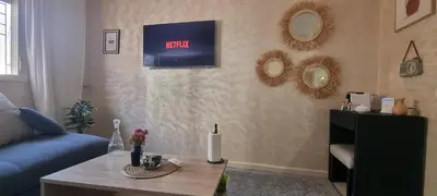 a living room with a couch and a clock on the wall at Cozy appartement à Marrakesh in Marrakech