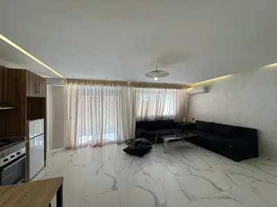 a living room with a couch and a table at Spacieux Appartement avec terrasse coeur de Marrakech in Marrakech