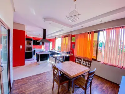a kitchen with a table and chairs and red walls at Amlkis golf royal in Marrakech