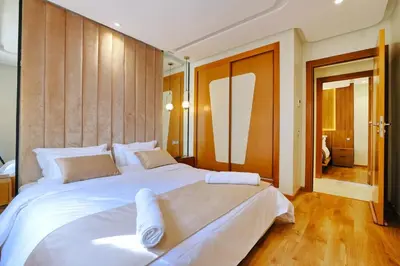 a bedroom with a large white bed with wooden floors at Awesome Luxury Apartment in Marrakech in Marrakech