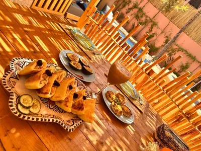 a wooden table with plates of food on it at Villa Riad Jawhar & SPA in Marrakech
