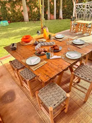 a wooden table with plates of food on it at Villa Riad Jawhar & SPA in Marrakech