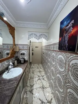 a bathroom with a sink and a large painting on the wall at Airport Apartment 5 minutes walk, perfect for Early & Late Flights in Marrakech