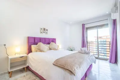 a bedroom with a large bed with a purple headboard at NEW! appt au cœur de Gueliz ,Terrasse,IPTV,parking in Marrakech