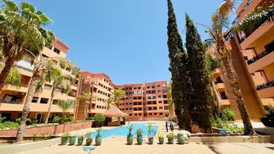 a resort with a swimming pool and palm trees and buildings at - Résidence Babylone Y - 1 Bedroom Appartement in Marrakech