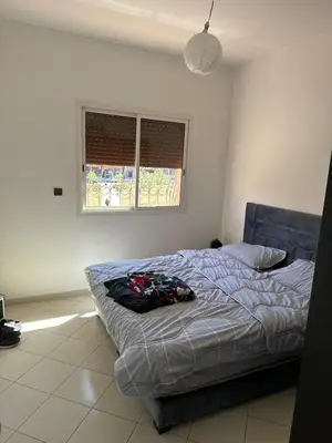 a bedroom with a bed and a window at Sharing Apartment Standard Room in Marrakech