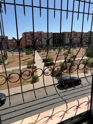 a car parked on a street behind a fence at Sharing Apartment Standard Room in Marrakech