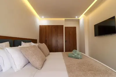 a bedroom with a white bed with a flat screen tv at Appartement, Gueliz, WiFi, parking in Marrakech