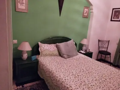 a bedroom with a bed with pink and green walls at زنقة ابو حنيفه in Marrakech