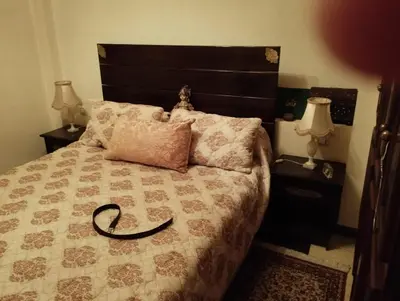 a bedroom with a bed with a wooden head board at زنقة ابو حنيفه in Marrakech