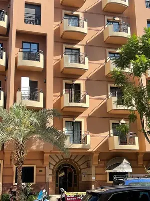 a large building with balconies and palm trees in front of it at زنقة ابو حنيفه in Marrakech