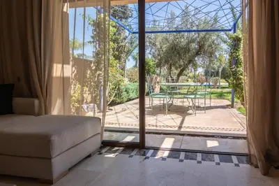 a living room with a sliding glass door with a patio at Appartement moderne et chic, avec piscine pour femmes et Parc de jeux in Dar Caïd Layadi