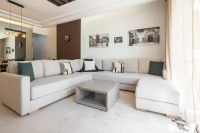 a living room with a white couch and a table at Appartement moderne et chic, avec piscine pour femmes et Parc de jeux in Dar Caïd Layadi