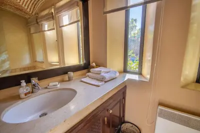 a bathroom with a sink and a mirror and a window at Amelkis golf villa 3 ch private pool in Marrakech