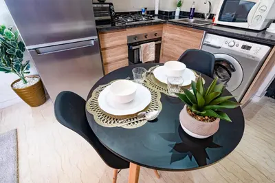 a kitchen with a table and chairs and a kitchen with a dishwasher at Élégant avec Parking - Guéliz Hivernage in Marrakech