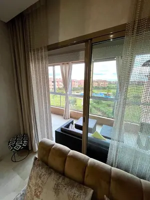 a living room with a couch and a large window at Appartement de luxe prestigia agate Marrakech in Marrakech