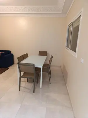 a dining room with a white table and chairs at Excellente appartement 3 chambres in Marrakech