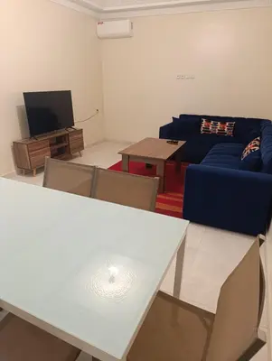 a living room with a blue couch and a tv at Excellente appartement 3 chambres in Marrakech