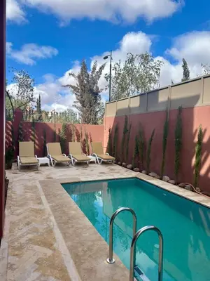 a swimming pool with chairs next to a fence at Villa De Luxe Marrakech Targa in Marrakech