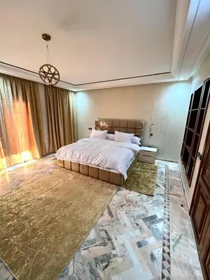 a bedroom with a large bed and a chandelier at Villa De Luxe Marrakech Targa in Marrakech