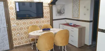 a room with a table with chairs and a television on the wall at Portes de Guéliz in Marrakech