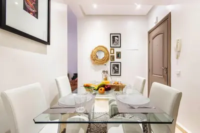 a dining room with a glass table and white chairs at Au coeur Hivernage Proche M avenue in Marrakech