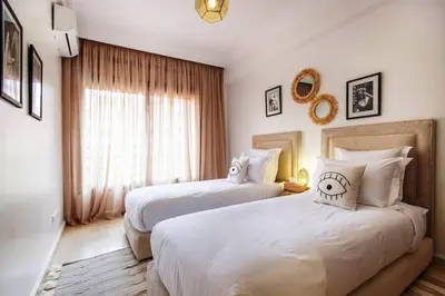 a bedroom with two beds and a window at Au coeur Hivernage Proche M avenue in Marrakech