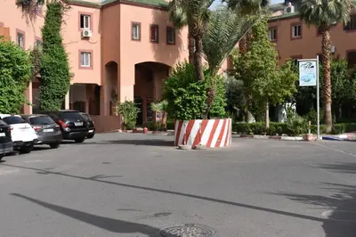 a parking lot with cars parked in front of a building at Riad Zaitone 134 in Marrakech