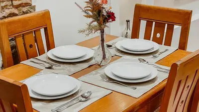 a wooden table with white plates and silverware on it at Appartement 1ch Hivernage avec Piscine in Marrakech