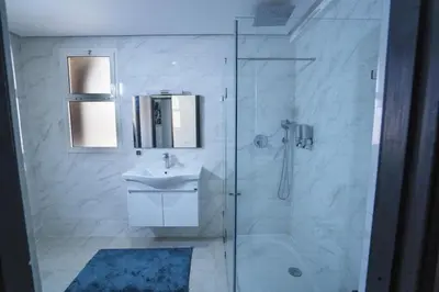 a bathroom with a glass shower with a sink and a toilet at Villa Bonsai Marrakech in Marrakech