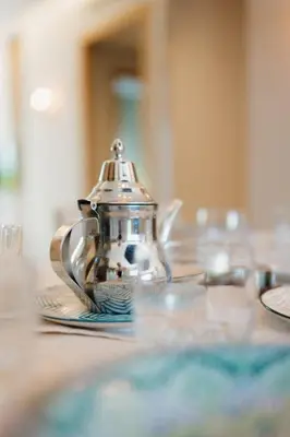 a tea pot sitting on a table with a plate at Appartement Cosy avec Parc et Piscine pour femme in Marrakech