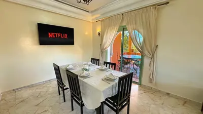 a dining room with a white table and chairs at Modern Apartment in a Resort Luxury and Comfort in Marrakech