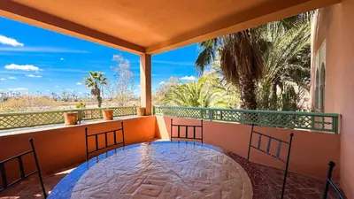 a balcony with a view of the ocean and palm trees at Modern Apartment in a Resort Luxury and Comfort in Marrakech