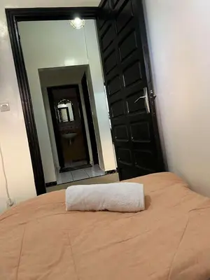 a white towel on a bed in front of a mirror at Palm Residence in Marrakech
