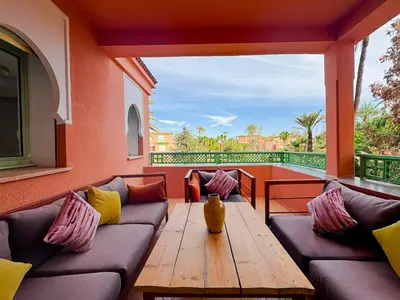 a patio with a couch and a wooden table at Luxurious Duplex in a Peaceful Resort in Marrakech in Marrakech