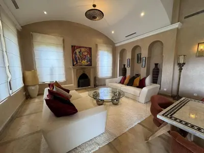 a living room with white furniture and a fireplace at Villa Hilin - Piscine chauffée et hammam privé proche des golfs et du centre ville in Marrakech