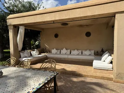 a patio with couches and a table and a table and chairs at Villa Hilin - Piscine chauffée et hammam privé proche des golfs et du centre ville in Marrakech