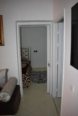 a living room with a door open to a room with a couch at Apartment A Zaitone G19 in Marrakech