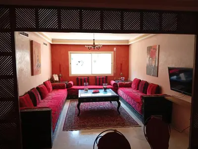 a living room with a red couch and a tv at Appartement de luxe Résidence Majorelle in Marrakech
