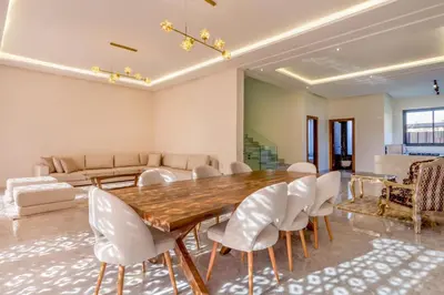 a dining room with a wooden table and white chairs at Villa Esma in Marrakech