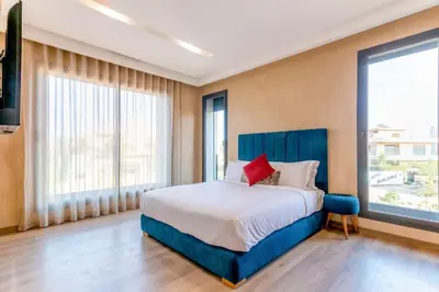 a bedroom with a large bed and large windows at Villa Esma in Marrakech