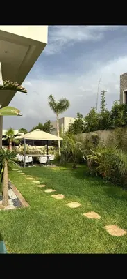 a green yard with a bench and a pavilion at Villa coco in Marrakech