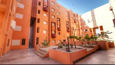 a large orange building with a courtyard with plants at Studio de luxe à Gueliz Marrakech in Marrakech