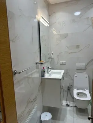 a white bathroom with a sink and a toilet at Studio de luxe à Gueliz Marrakech in Marrakech