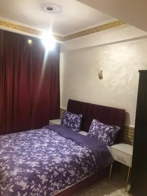 a bedroom with a purple bed and a red curtain at Résidence Babylone Y - Appartement Studio in Marrakech
