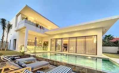 a large house with a swimming pool in front of it at Luxueuse Villa 5 suites Golf de Noria in Marrakech