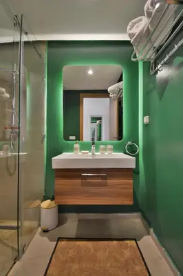 a green bathroom with a sink and a mirror at Appartement Domaine de Noria 7 in Marrakech